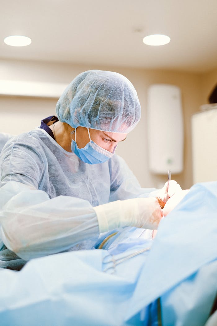 about-02 A skilled surgeon in sterile attire performing a medical procedure in an operating room.